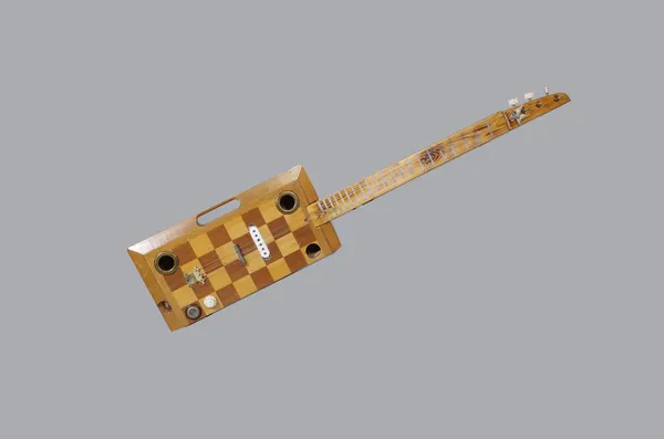 A novelty scratch built three string electric guitar, the body built from half a chessboard, 100cm long.