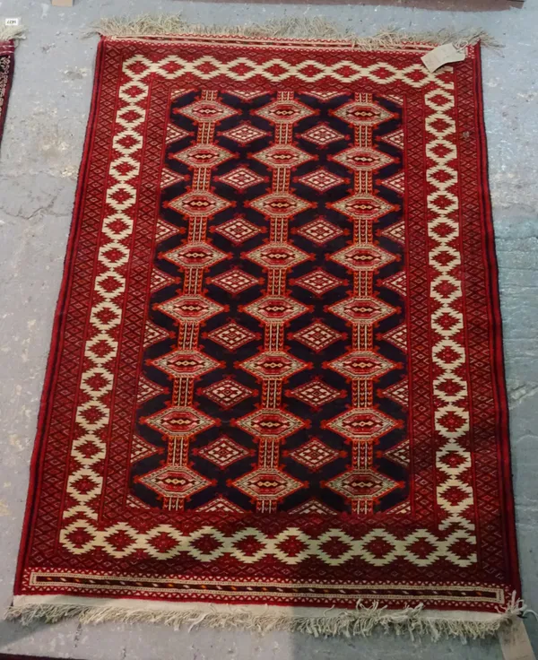 An Indian rug of Turkeman design, the black field with three columns of connecting diamonds, supporting diamonds, an ivory stepped motif border, 139cm