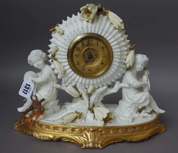 A Moore Bros porcelain mantel clock, late 19th century, the drum case flanked by musical figures, with applied flowers on a shaped gilt base, pink pri