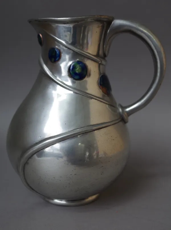 A Liberty Tudric pewter jug, after a design by Archibald Knox, with enamelled roundels to the bulbous body, no. 052, stamped marks, 18.5cm high.