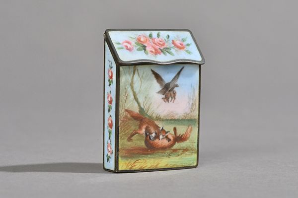 A Victorian enamel vesta case decorated with playful foxes, a lady and hound and wild bird within a foliate border against a rectangular body with hin