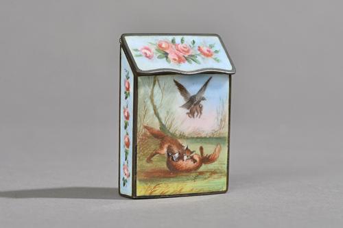 A Victorian enamel vesta case decorated with playful foxes, a lady and hound and wild bird within a foliate border against a rectangular body with hin