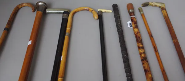 An early 20th century wooden 'pipe' gadget walking cane (89cm), a malacca walking cane with silver pommel (91cm), an Irish bog oak walking cane with c