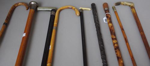An early 20th century wooden 'pipe' gadget walking cane (89cm), a malacca walking cane with silver pommel (91cm), an Irish bog oak walking cane with c