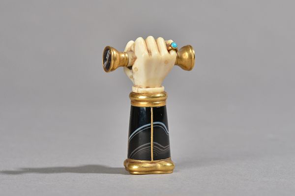 A Victorian agate, gilt metal and ivory set seal, possibly Masonic, modelled as a fist clenching a scroll with separate matrix at either end, the larg