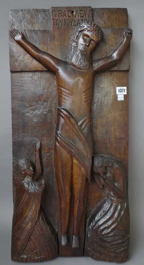 A 19th century carved walnut plaque depicting the crucifixion, 75cm x 35cm x 7cm) and a carved oak figural corbel, 33cm. (2)