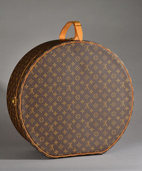 A Louis Vuitton hat box or 'Boite Chapeaux 50', monogram canvas and brass hardware, with leather card holder and two keys, 50cm diameter. Illustrated.