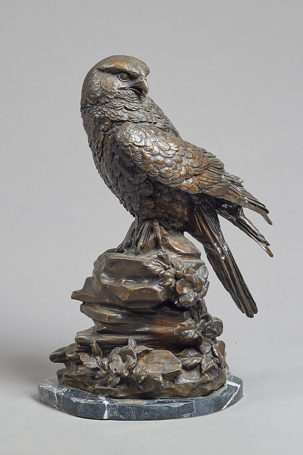 A patinated bronze bird of prey, late 20th century, on a naturalistic rocky outcrop and marble plinth, unsigned, 59cm high overall. .