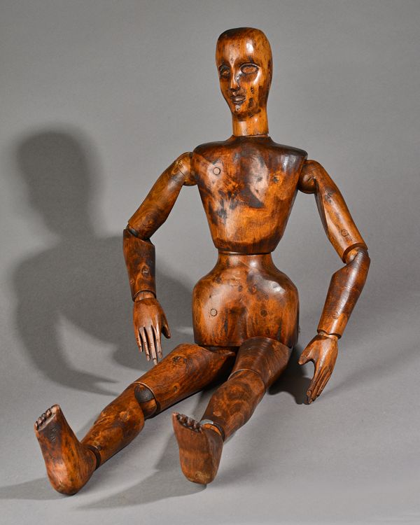 A stained beech artist's lay figure, 20th century, with articulated torso and limbs, 80cm high. Illustrated.