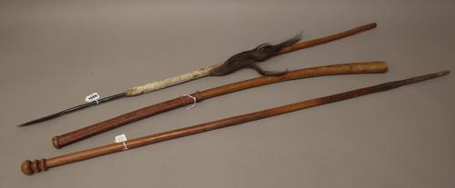 A South African stabbing spear with carved wooden shaft and animal skin/hair decoration (112cm), a carved bentwood club with leather bound grip (93cm)