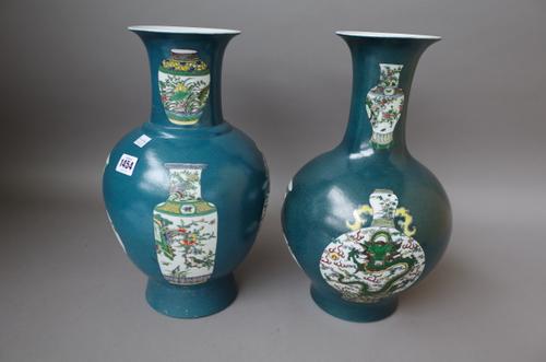 Two modern Chinese green ground vases each decorated with panels of famille verte vases, 37cm high and another similarly decorated blue ground vase, 4