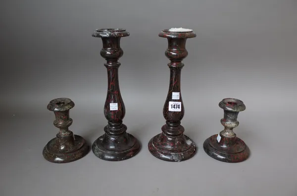 A pair of serpentine candlesticks of turned baluster form on a stepped circular foot, 29.5cm high and a similar, smaller pair, 13.5cm high. (4)