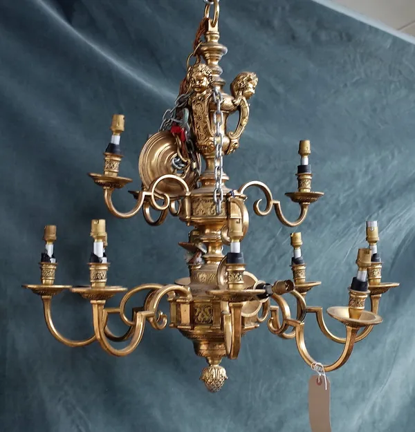 A modern gilt bronze twelve branch chandelier of Renaissance style, with three cherub surmounts over a turned bulbous column issuing twelve S-shaped b