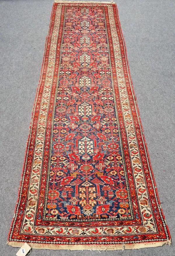 A Hamadan runner with all-over stylised floral design on a midnight blue ground with ivory main border, approximately 410cm x 106cm.