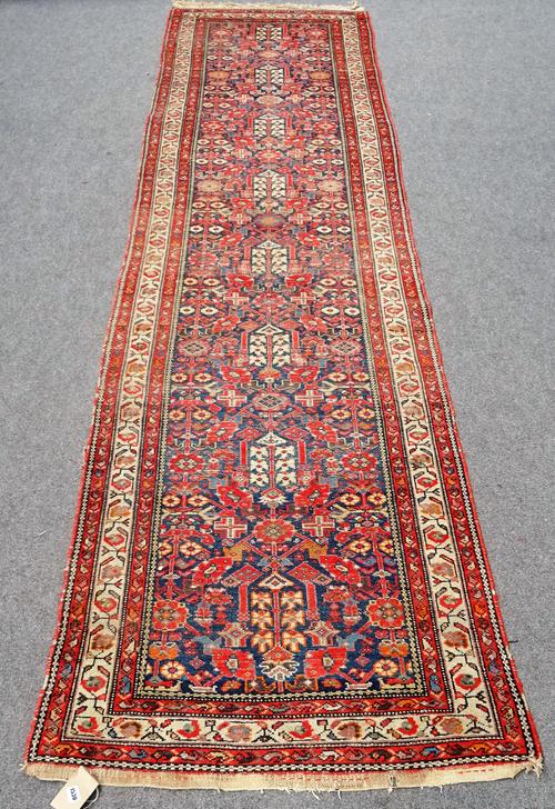 A Hamadan runner with all-over stylised floral design on a midnight blue ground with ivory main border, approximately 410cm x 106cm.