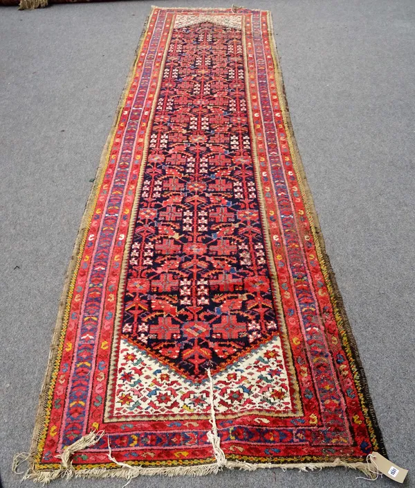 A Hamadan runner, with all-over stylised floral design on a midnight blue ground with white spandrel ends, approximately 406cm x 104cm (damages).