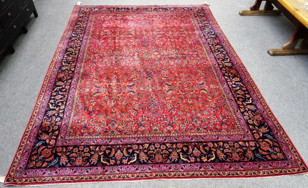 A fine Kashan carpet Persian, the madder field with an allover floral design, a dark indigo bird and triple flower medallion, 363cm x 264cm.