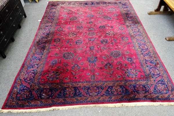 A Mashed carpet, Persian, the burgundy field with an allover floral design, an indigo palmette border, 402cm x 290cm.