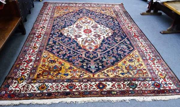 A Bakhtiar carpet, Persian, the dark indigo field with a bold ivory medallion, brown/orange spandrels, all with angular vines an ivory complimentary b