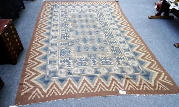 A Bessarabian kelim, the grey field with single motifs and an outer surround of stylised vases, an outer brown chevron border, 376cm x 267cm.