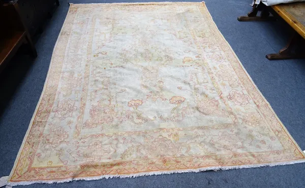 A Turkish carpet, the ivory field with a central pale medallion and matching spandrels, a complimentary border, 401cm x 290cm.