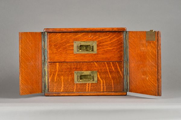 A Victorian brass mounted oak table cabinet, the pair of doors enclosing a pair of drawers, 30cm wide x 25cm high. Illustrated.