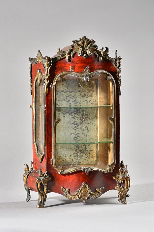 A 19th century travelling tradesman's diminutive gilt metal mounted tortoiseshell veneered vitrine, with glazed serpentine front and sides, 24cm wide