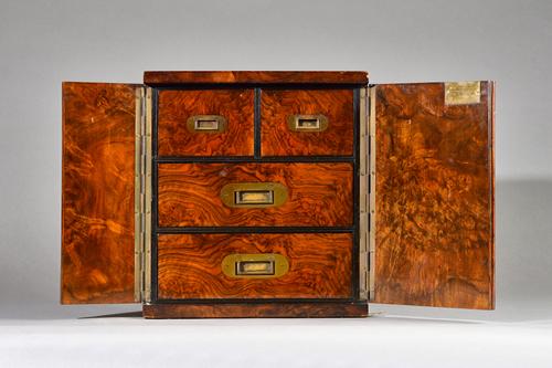 A Victorian brass bound figured walnut table top cabinet, the pair of doors enclosing two short and two long drawers, 30cm wide x 32cm high. Illustrat
