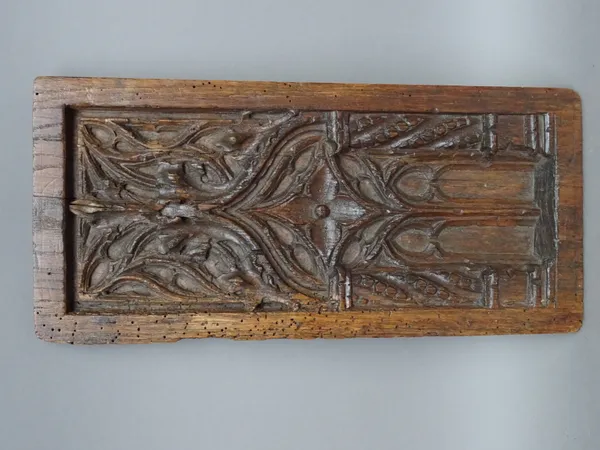 A 17th century carved oak tracery panel, 15cm wide x 32cm high.