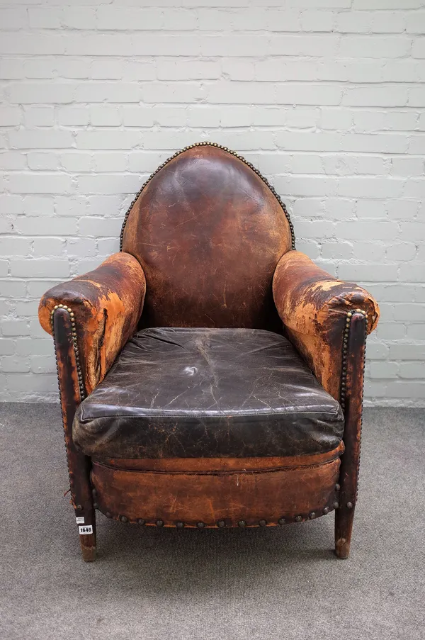 A mid-20th century French brown leather upholstered easy armchair with pointed arch back, 75cm wide x 100cm high.