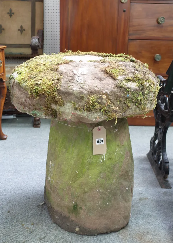 An iron stone staddle stone with mushroom top and conical body, 60cm diameter x 73cm high, together with a similar granite example, 54cm diameter x 78