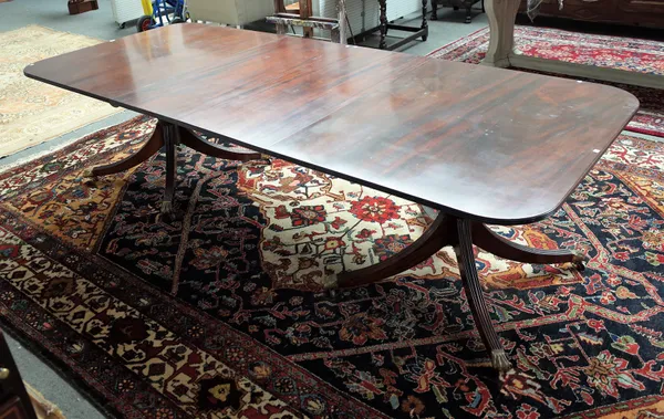 A Regency style mahogany twin pillar extending dining table on eight downswept supports, two extra leaves, 114cm wide x 182cm long x 273cm fully exten