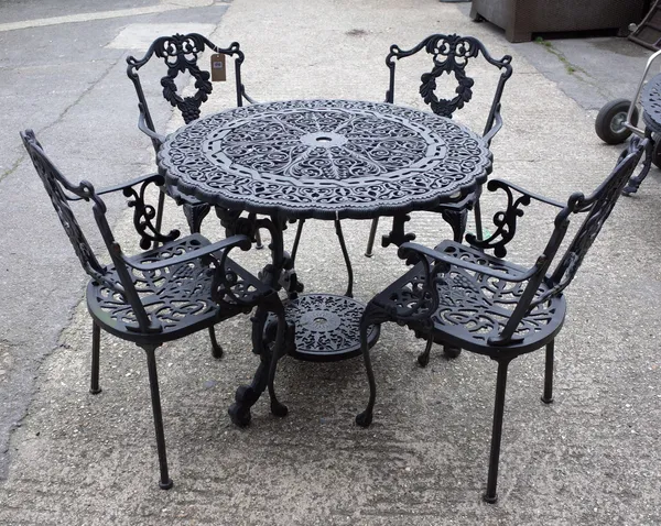 A 20th century black painted cast iron circular garden table, with pierced decoration, 92cm diameter, together with four armchairs, (5).