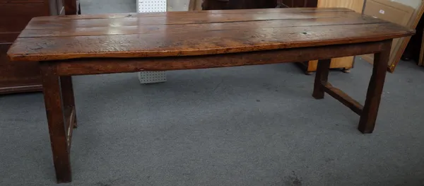 An 18th oak and elm refectory table, the plank top on block supports, united by short stretchers, 74cm wide x 227cm long.