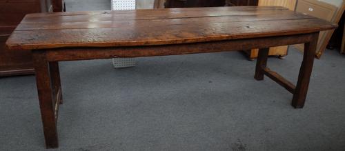 An 18th oak and elm refectory table, the plank top on block supports, united by short stretchers, 74cm wide x 227cm long.
