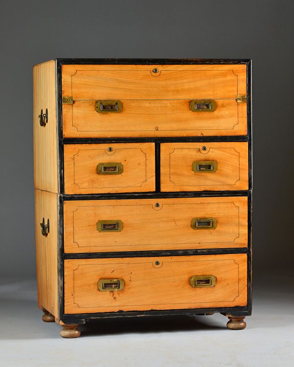 A 19th century Anglo-Indian ebony bound camphor wood two part campaign chest, the top drawer with pull out fitted writing slope interior above two sho