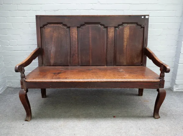 An 18th century oak settle with triple panel back on cabriole supports, 141cm wide x 108cm high.