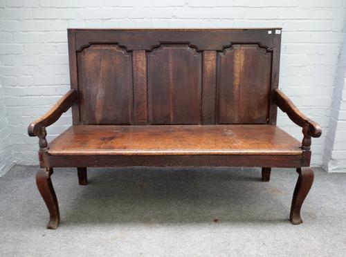 An 18th century oak settle with triple panel back on cabriole supports, 141cm wide x 108cm high.