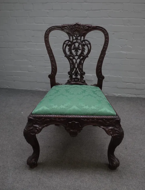 A profusely carved 19th century mahogany side chair, of George II design, with pierced splat and shaped frieze on scroll supports, 67cm wide x 95cm hi