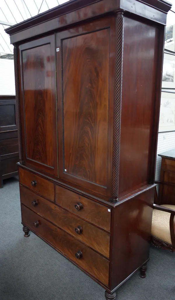 A William IV linen press, the pair of panel doors over two short and two long drawers on turned feet, 138cm wide x 217cm high.