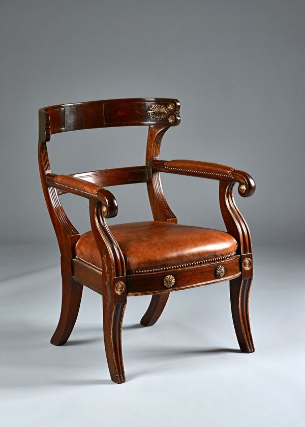 A French Empire Revival leather upholstered parcel gilt mahogany open armchair on sabre supports, 62cm wide x 87cm high. Illustrated.