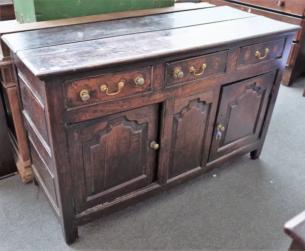 A mid-18th century oak dresser base with three frieze drawers over pair of arch panel cupboards, 147cm wide x 93cm high.