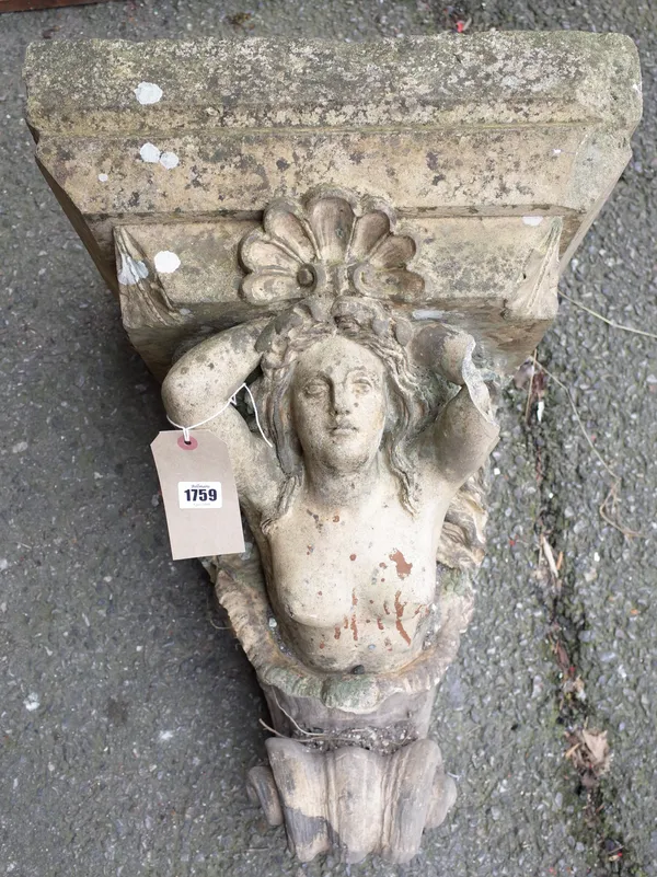 A large 19th century reconstituted stone wall bracket, formed as a naked female emerging from cornucopia, 42cm wide x 60cm