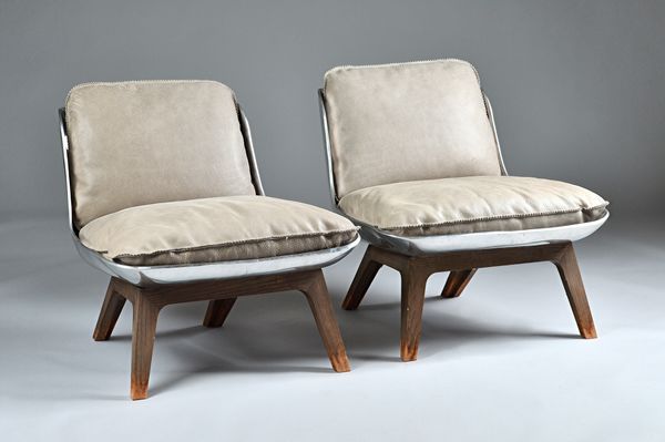 BAXTER design by Paola Navone; a pair of polished steel easy chairs on stained beech supports with loose leather cushions, 67cm wide x 61cm high (2).