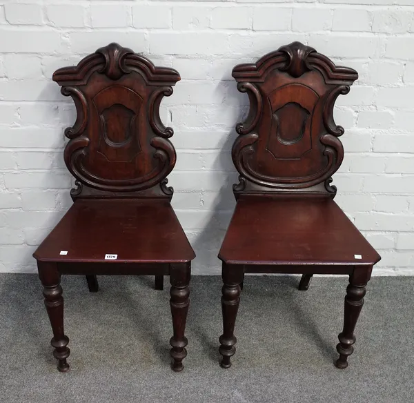 A pair of Victorian mahogany shield back hall chairs, on turned supports, 44cm wide x 89cm high (2).