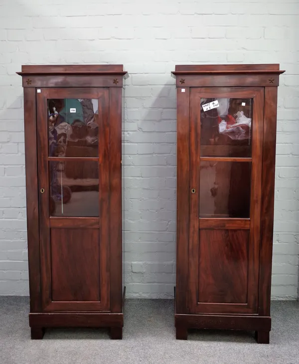 A pair of early 19th century Continental floor standing display cabinets, each with single glazed door on block feet, 62cm wide x 163cm high, (2).