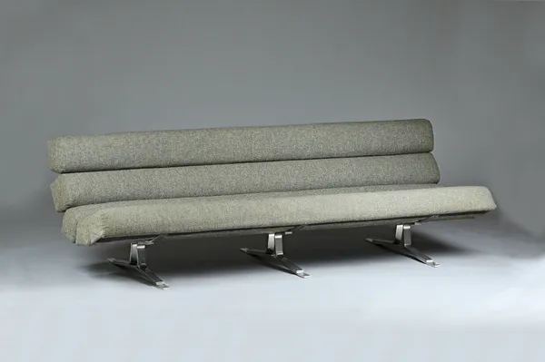 William Plunkett Kingstone; a mid 20th century grey upholstered sofa, with tubular cushions on polished steel supports, 210cm wide x 65cm high. Illust