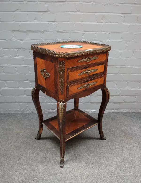 A late 19th century French gilt metal and ceramic mounted Kingwood and rosewood lift top work table, with a pair of frieze drawers on cabriole support