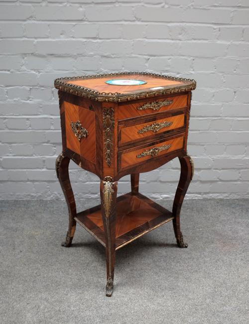A late 19th century French gilt metal and ceramic mounted Kingwood and rosewood lift top work table, with a pair of frieze drawers on cabriole support