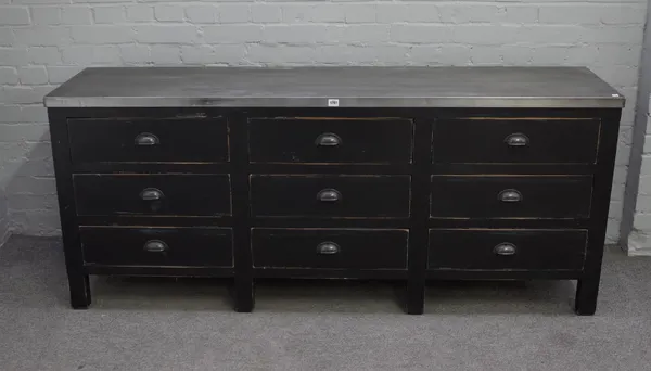 A zinc topped side cabinet, the ebonised base with three rows of three drawers, 182cm wide x 77cm high.